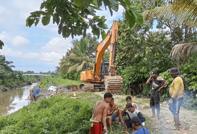 Warga Desa TetEuri Kecamatan Sabbang Selatan bergotong royong perbaiki tanggul rusak dengan bantuan alat berat dari Pemerintah Desa, Selasa, 21 Mei 2024.