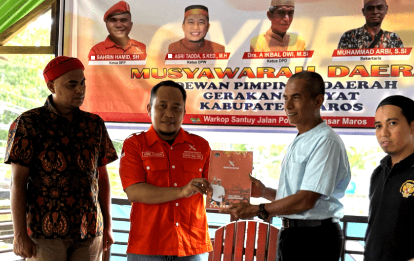 Ketua DPW Gerakan Rakyat Sulsel Asri Tadda menyerahkan Buku Jingga GR kepada Ketua DPD GR Maros terpilih, Andi Ikbal Dwi di acara Musda Gerakan Rakyat (GR) Kabupaten Maros, Sulawesi Selatan, Senin (28/4/2025).